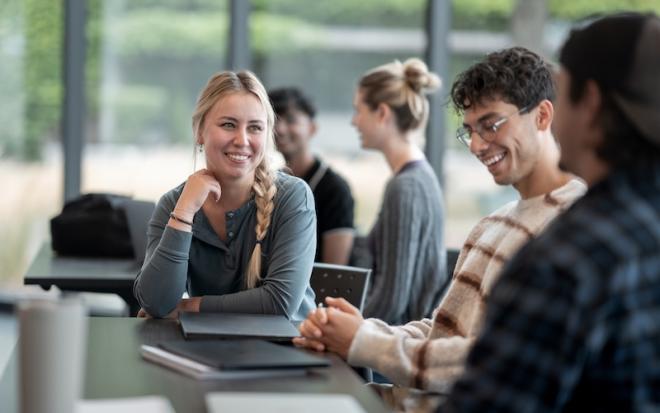 students in classroom smile and interact